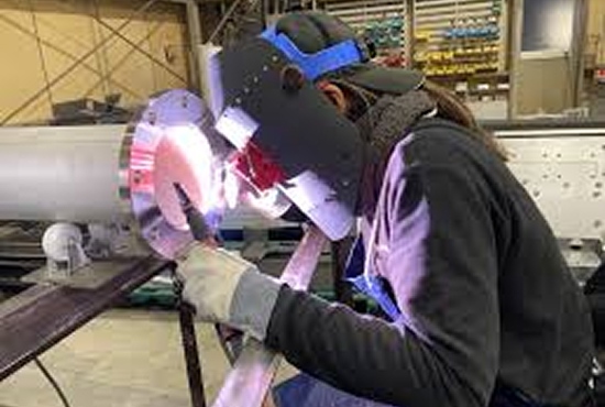 図面を確認しながら溶接作業に集中する女性社員